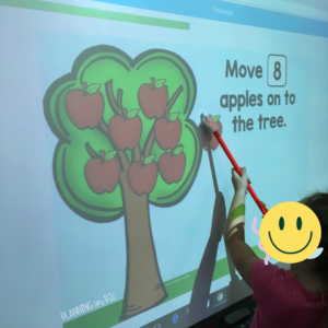 Student playing counting apples Boom Cards™ on Smartboard